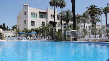 Una piscina al aire libre de temporada, sombrillas