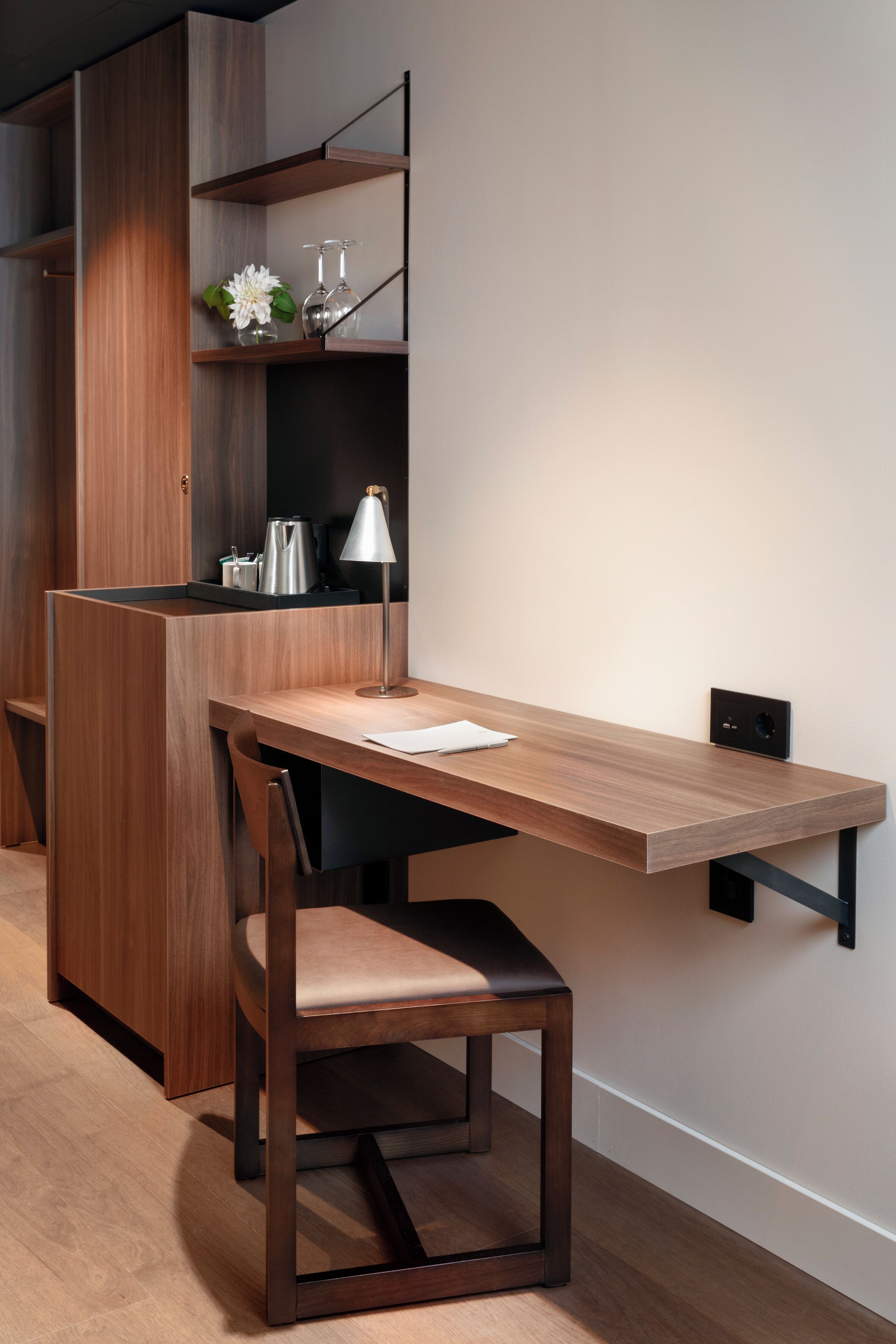 Un espacio de trabajo moderno con escritorio de madera, silla y estanterías integradas.