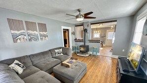 A living room with a sectional sofa, ottoman, and a fireplace. - Charming Cascade Cabin: Large Yard, Near Downtown! (Cascade)