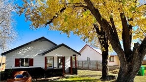A two-story house with a front porch and a garage. - Charming Cascade Cabin: Large Yard, Near Downtown! (Cascade)