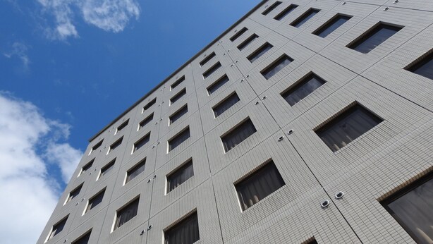 Un edificio alto con una fachada de ventanas y un cielo despejado.