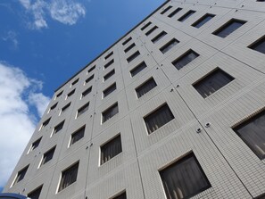 A high-rise building with a grid of windows and a clear sky. - Fuchudaiitihoteru (Fuchu)