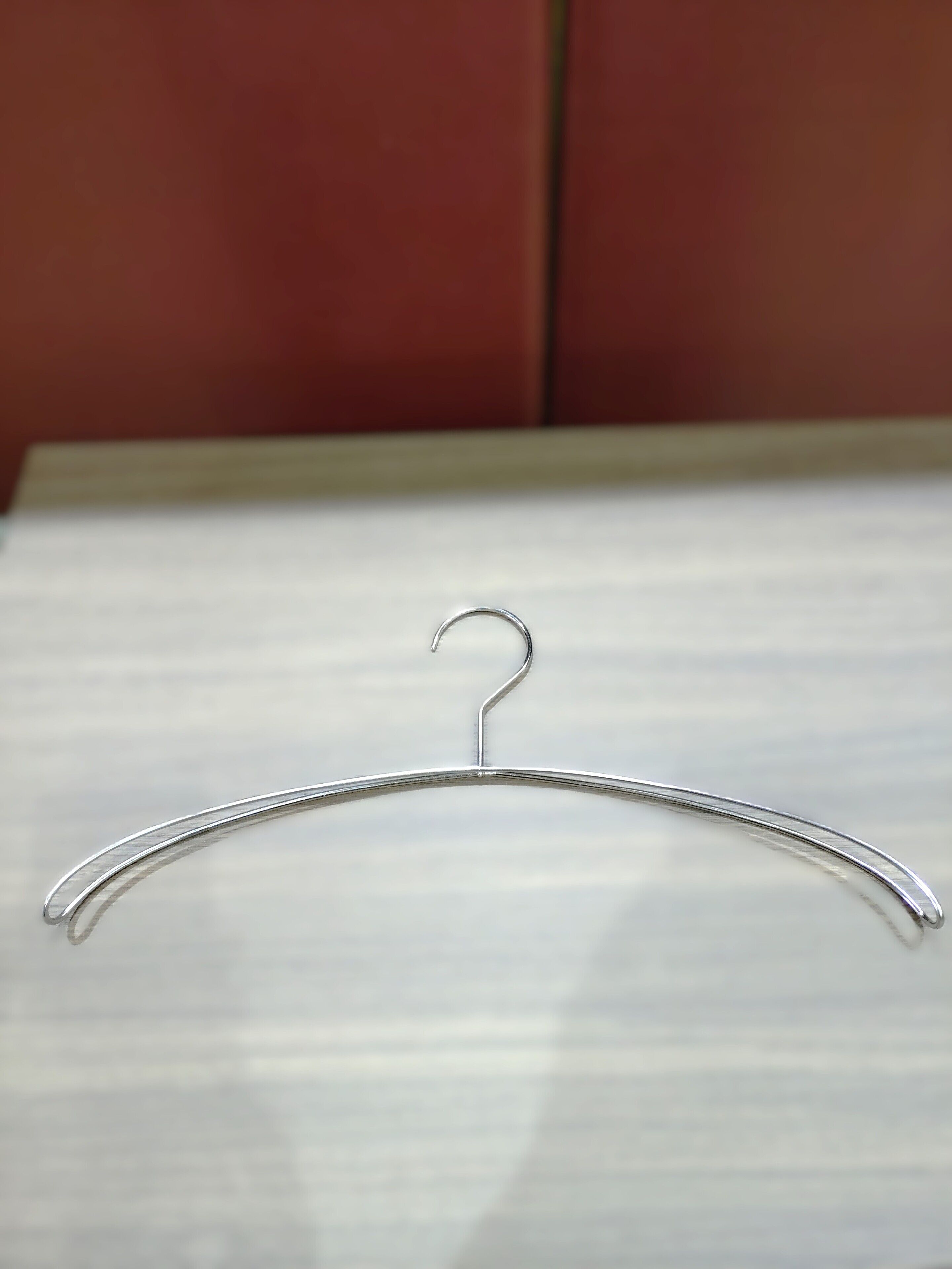 A metal hanger on a white surface.