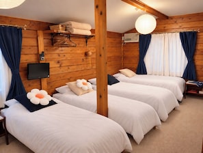 A room with two beds, a flat-screen TV, a heater, and a ceiling fan. - Pension Snowfall Meteor (Kaminoyama)