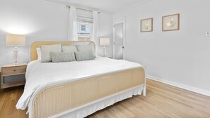 Una camera da letto con un letto, comodini, una ventola a soffitto e due lampade a parete.