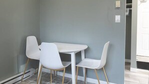 A small dining area with a white table and four white chairs.