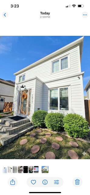 A two-story house with a front porch, a small front yard with stepping stones, and a mailbox. - Lovelyhome•Near BU•With TreeHouse•Ideal for group stays (Brandon)