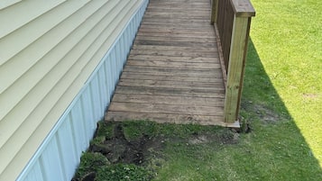 Une terrasse en bois qui mène à une maison offrant une vue sur un lac.
