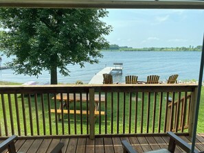 A wooden deck with a view of a lake, a dock, and a boat. - Steps Away From The Lake! (Glenwood)