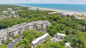 Ein Resort mit mehreren Gebäuden, einem Strand und einem Parkplatz.