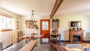 A spacious kitchen with a long island, wooden chairs, a dining table, a fireplace, and a television mounted on the wall. - The Bartlett Nook/ HOT TUB/ 3-BEDROOM/ 4 BEDS/ CLOSE TO LU (Lynchburg)