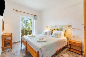 Un dormitorio con cama, muebles de madera, una ventana y vistas a zonas verdes.
