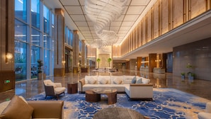 A spacious lobby with a modern chandelier, seating area, and large windows. - Suzhou International Conference Hotel (Suzhou)