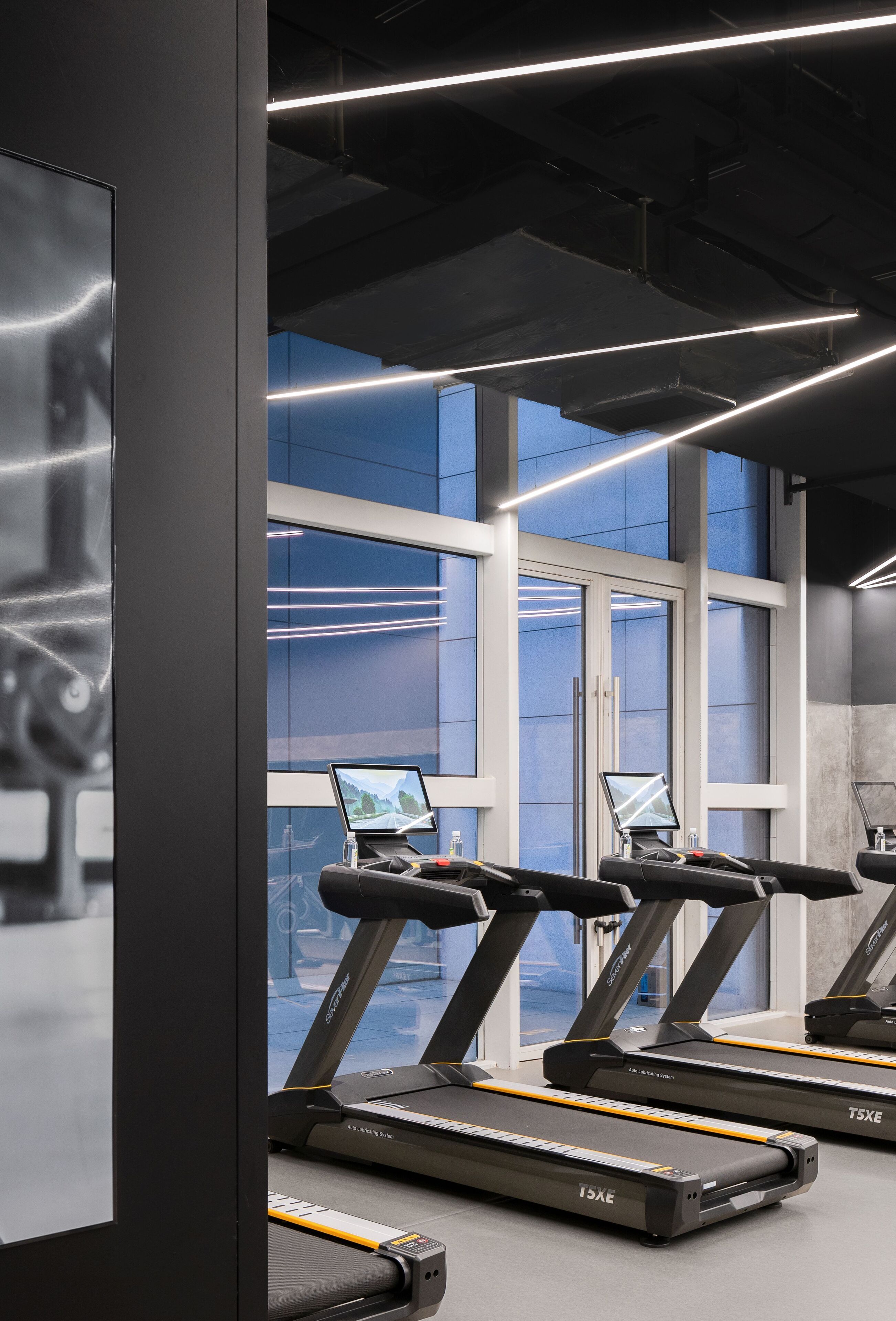 A gym with treadmills, large windows, and a modern design.