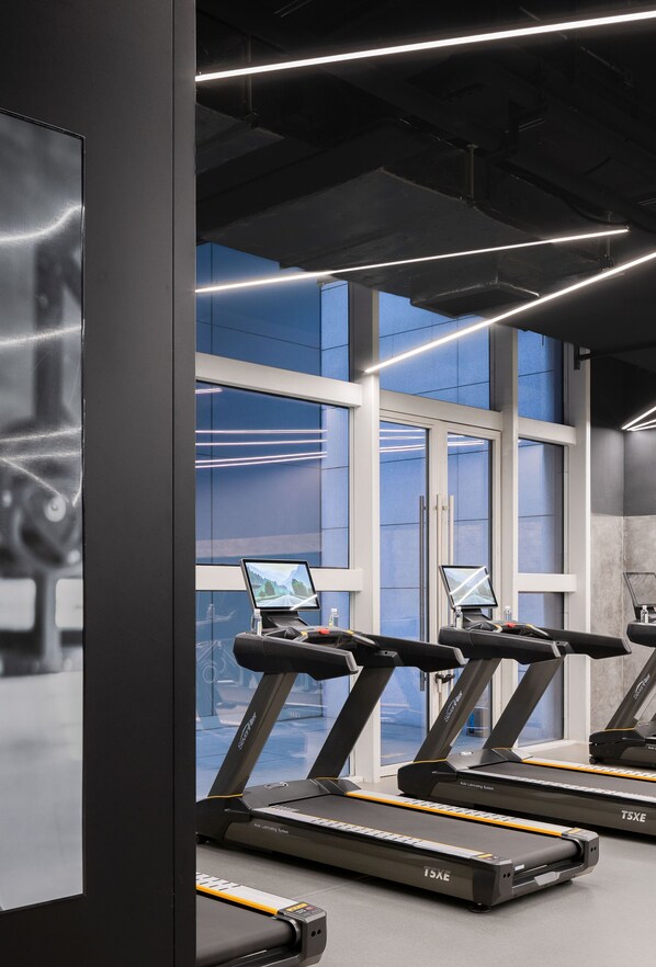 A gym with treadmills, large windows, and a modern design.
