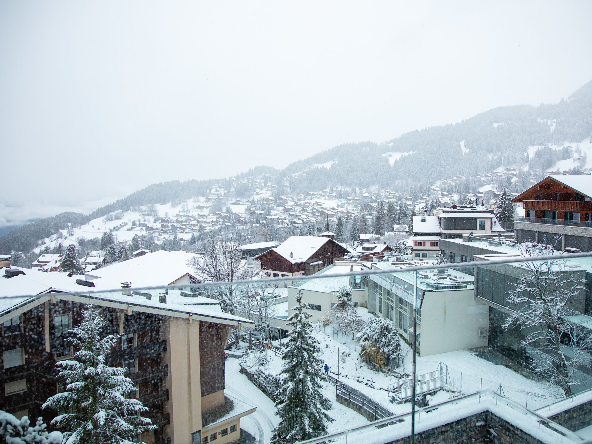 A snow-covered town with buildings and a mountain in the background.