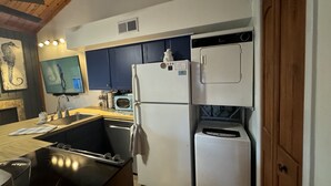 Uma cozinha moderna com forno embutido, micro-ondas e frigorífico.