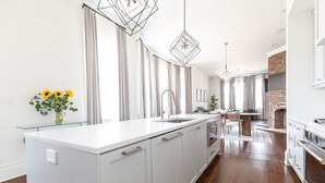 A modern kitchen with a central island, stainless steel appliances, and a brick oven. - Historic Charleston meets Modern luxury  (Charleston)