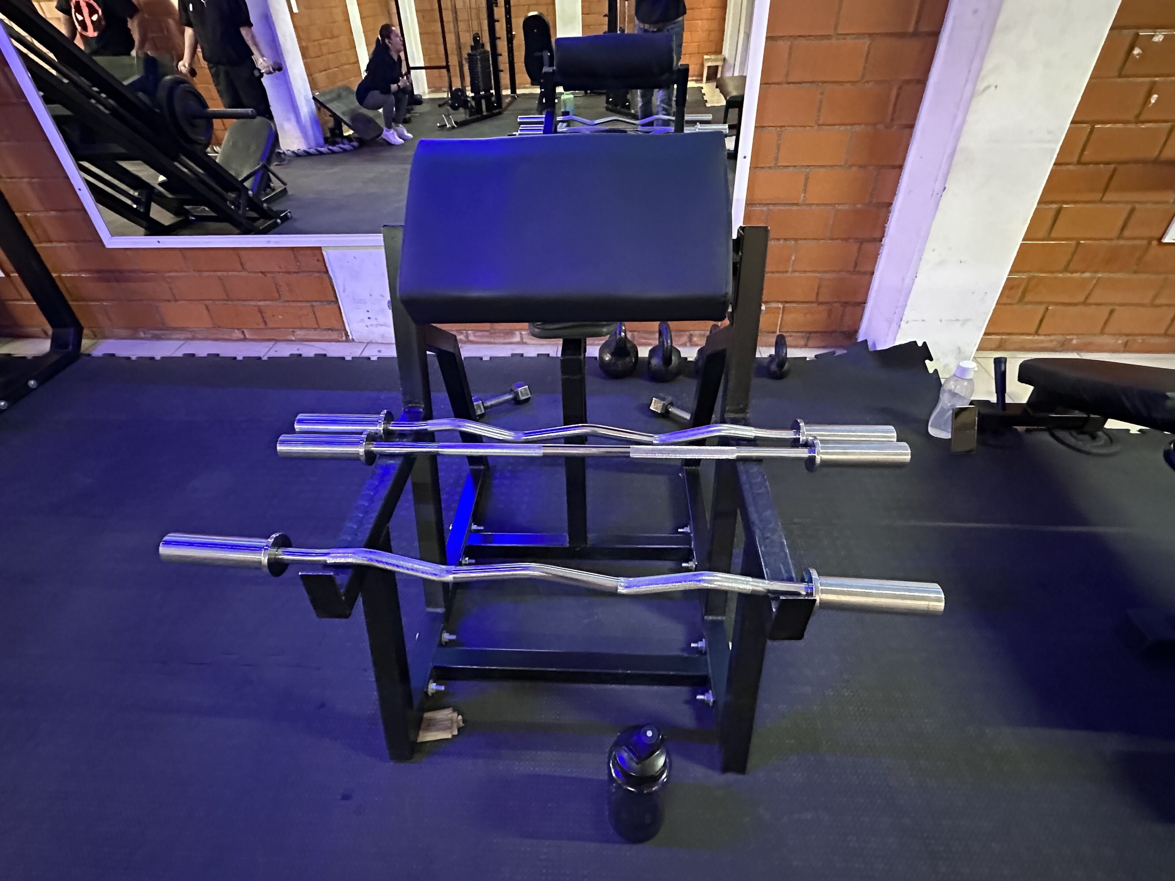 Una palestra con attrezzatura per l'allenamento con i pesi, tra cui bilancieri e manubri.