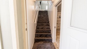 Eine Treppe mit dunklen Holzstufen und einem Teppich am Fuß.