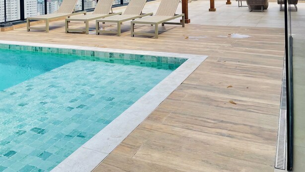 A rooftop pool area with lounge chairs and a pergola. - Apartamento Novo A 600 Metros DA Praia (Balneario Cidade Atlantica Guarujá)