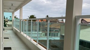 Un pasillo con barandas de vidrio y vistas a edificios.