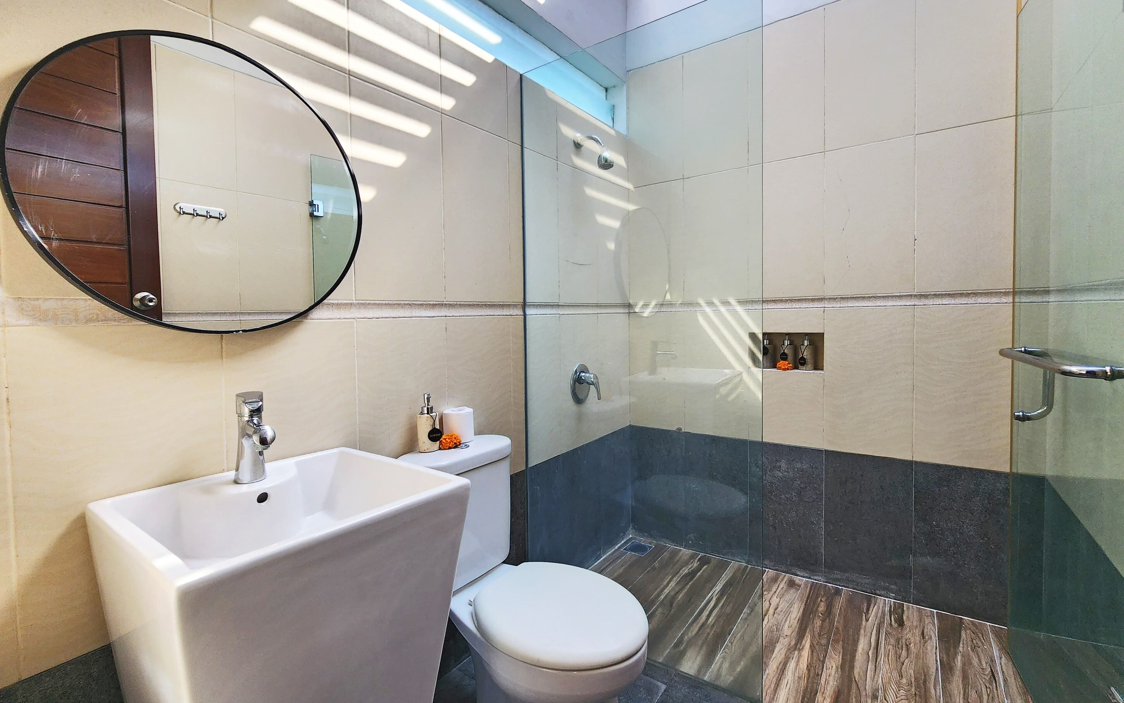A bathroom with a sink, toilet, and a glass-enclosed shower area.