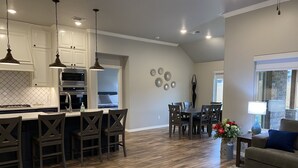 A modern kitchen with white cabinets, a central island, and pendant lighting.