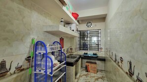 A compact kitchen with a sink, stove, and shelves. - Lovely two bed flats, by Dhaka Shahjalal Airport (Dhaka)