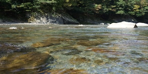 Un río de aguas cristalinas, rodeado de terreno rocoso y vegetación.