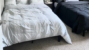 Ein Schlafzimmer mit zwei Betten, einem Nachttisch und einer Deckenleuchte.