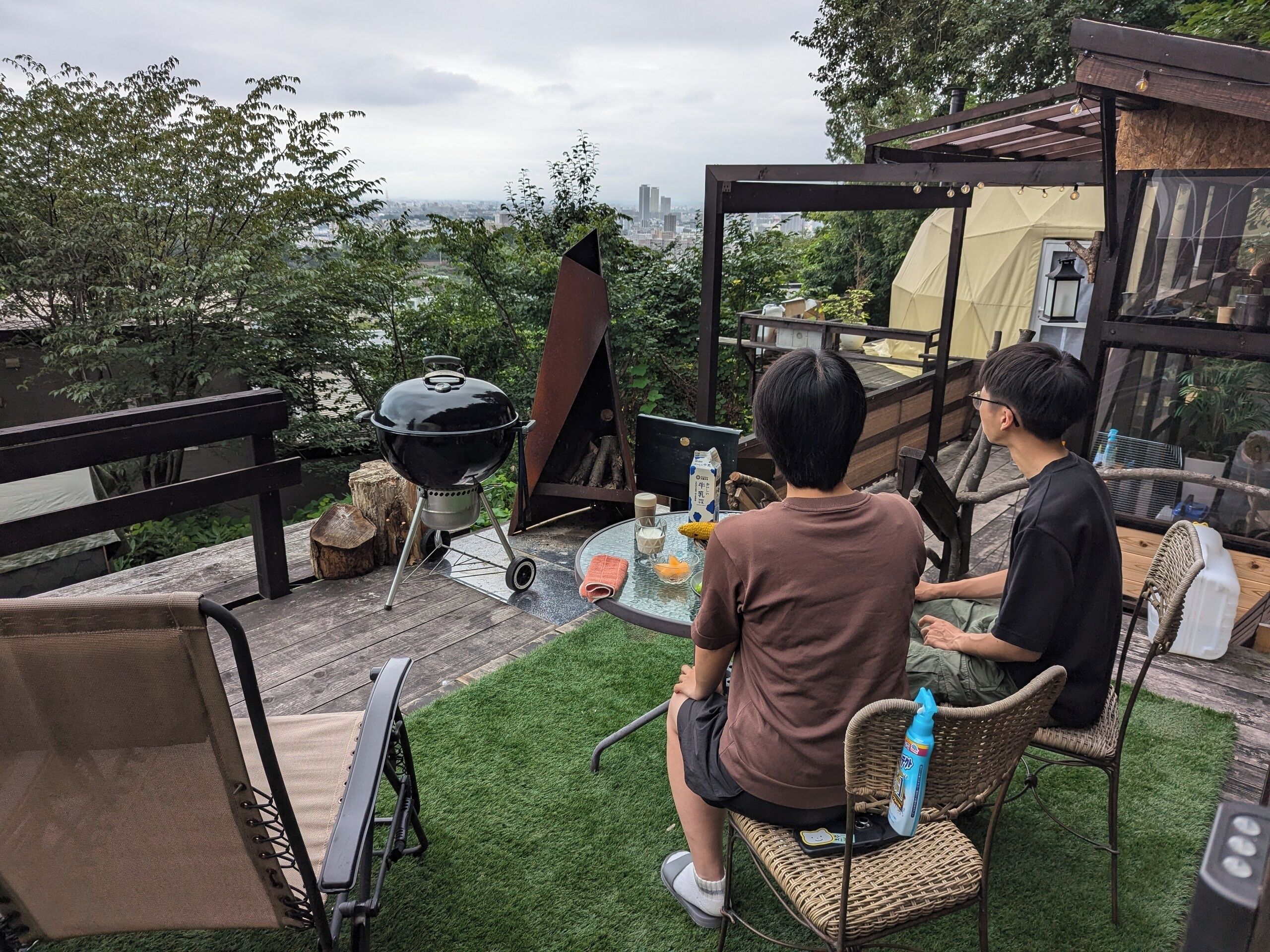 A patio with a grill, chairs, and a table.