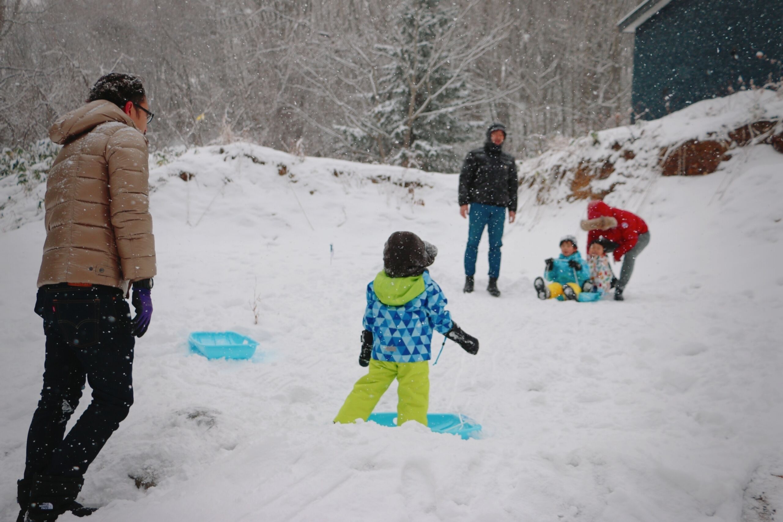 A snowy outdoor scene with people playing in the snow.