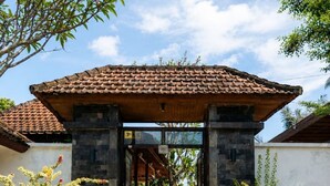 Un edificio tradizionale con tetto in tegole, ingresso in pietra e piante in vaso.