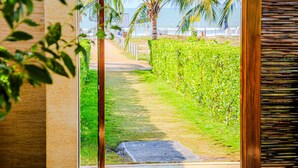 A pathway leading to a beach with palm trees and a wooden fence. - Exclusivo Apartamento 2Hab en Cartagena (Cartagena)