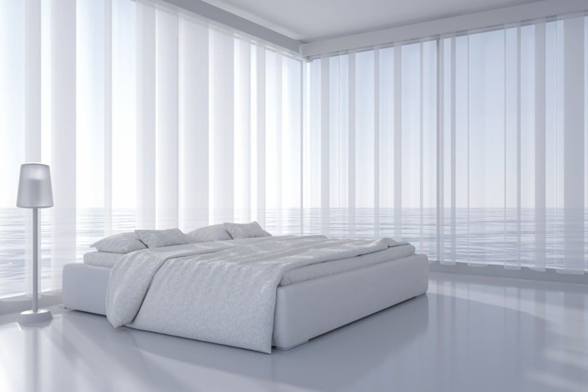 A modern bedroom with a large bed, a floor lamp, and large windows.
