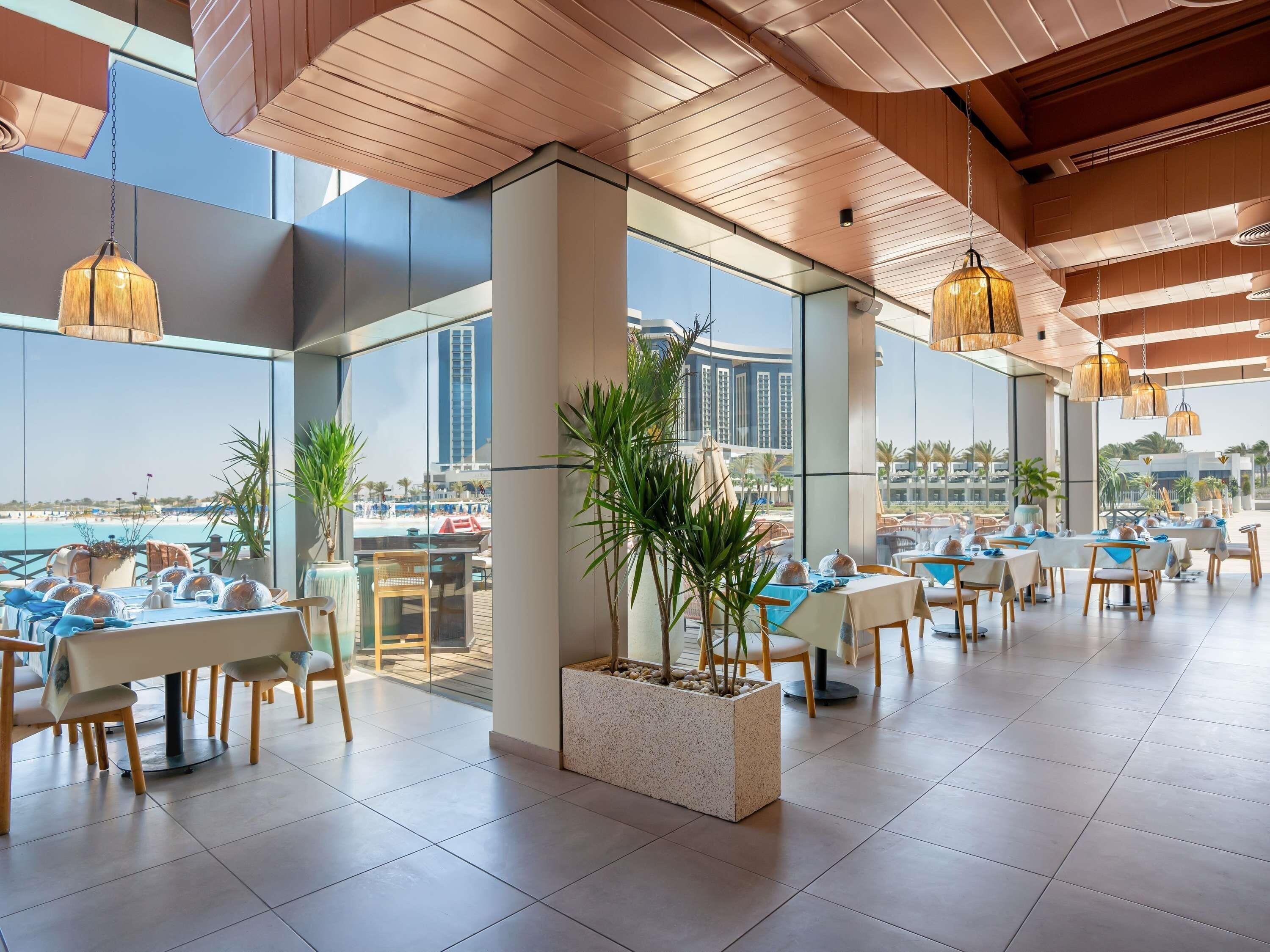 A modern dining area with tables, chairs, and hanging lights.