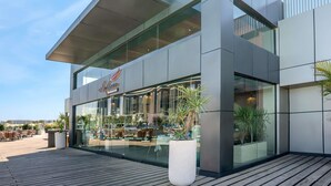 Un bâtiment moderne doté d’un toit plat, de grandes fenêtres et d’une enseigne indiquant « La Casa Restaurant ».