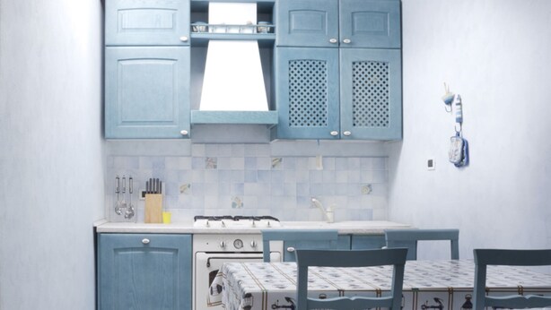 A compact kitchen with blue cabinets, a stove, and a sink. There is a table with chairs and a small window above the sink.