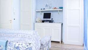 A bedroom with a bed, a desk with a computer, and a wardrobe.