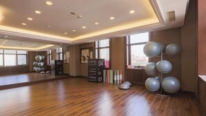 A spacious room with wooden flooring, a large mirror, and exercise balls arranged on shelves. - S&N Hotel Changzhou (Changzhou)