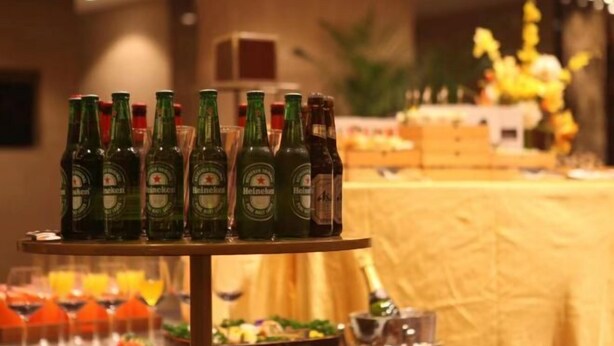 A table with multiple bottles of Heineken beer and a variety of food items. - S&N Hotel Changzhou (Changzhou)