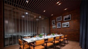 A conference room with a long table, orange chairs, wooden panel walls, and framed pictures. - S&N Hotel Changzhou (Changzhou)