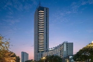 A tall hotel with a modern design, featuring a prominent vertical structure and multiple floors.