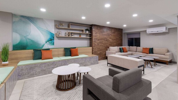 Ein modernes Wohnzimmer mit einem Ecksofa, einem runden Couchtisch und einer integrierten Bank mit Kissen.