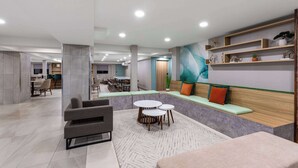 Ein stilvoller Lounge-Bereich mit Sitzgelegenheiten, Tischen und einer Zierwand.
