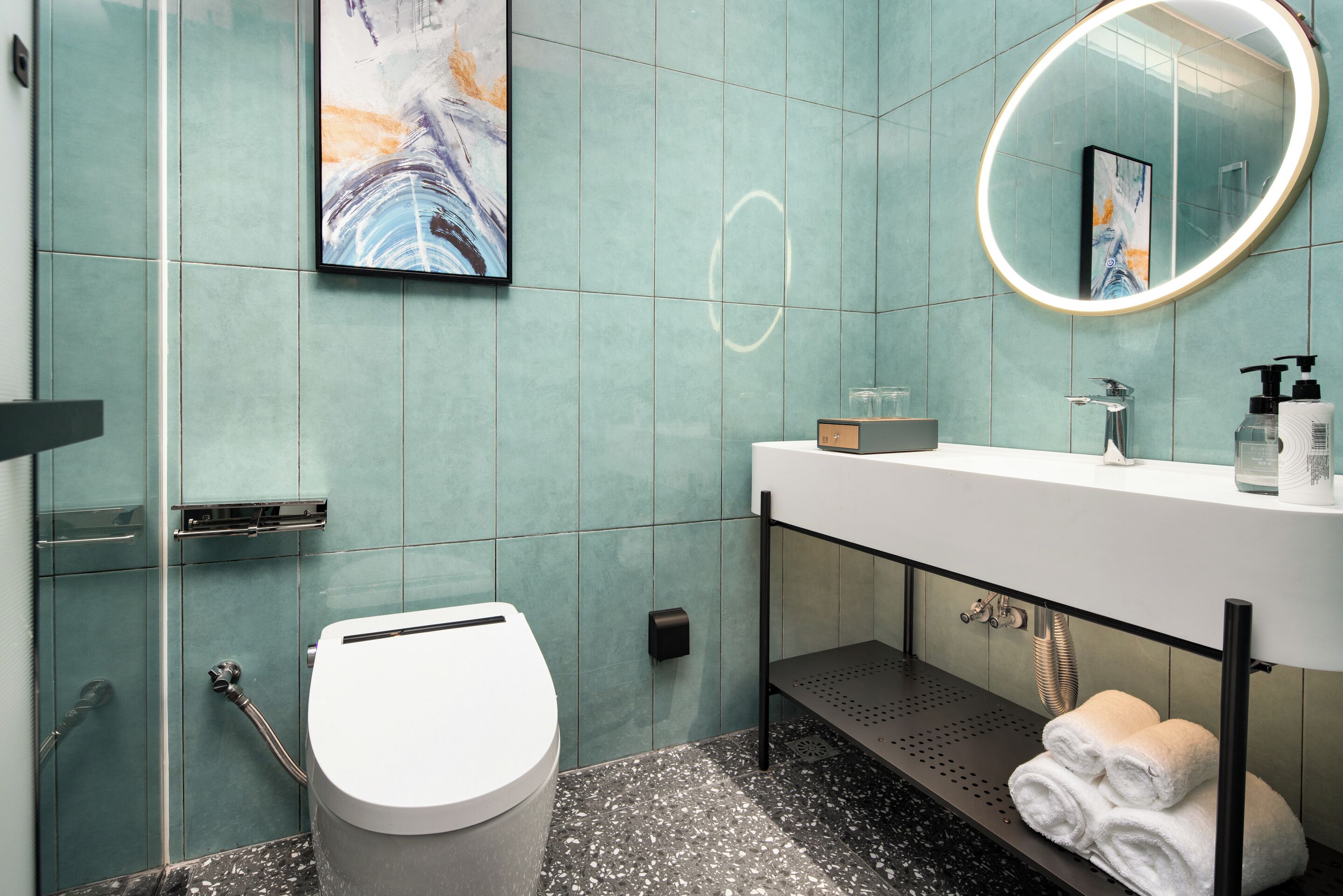 A bathroom with a toilet, sink, and a mirror.
