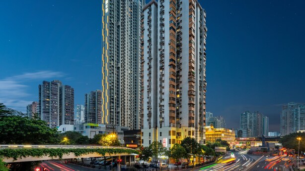 A high-rise building with multiple balconies and a well-lit entrance. - Yi Zhi Hotel (Pearl River Xincheng Store, Wuyangcun Metro Station, Guangzhou) (Guangzhou)