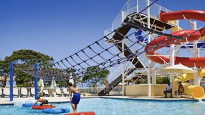 A pool area with water slides and inflatable rings. - Crea recuerdos inolvidables en este alojamiento único y familiar. (Sosúa)