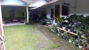 A covered outdoor area with a seating arrangement and a variety of potted plants. - Homestay Wijaya Mulya By Zuzu (Borobudur)